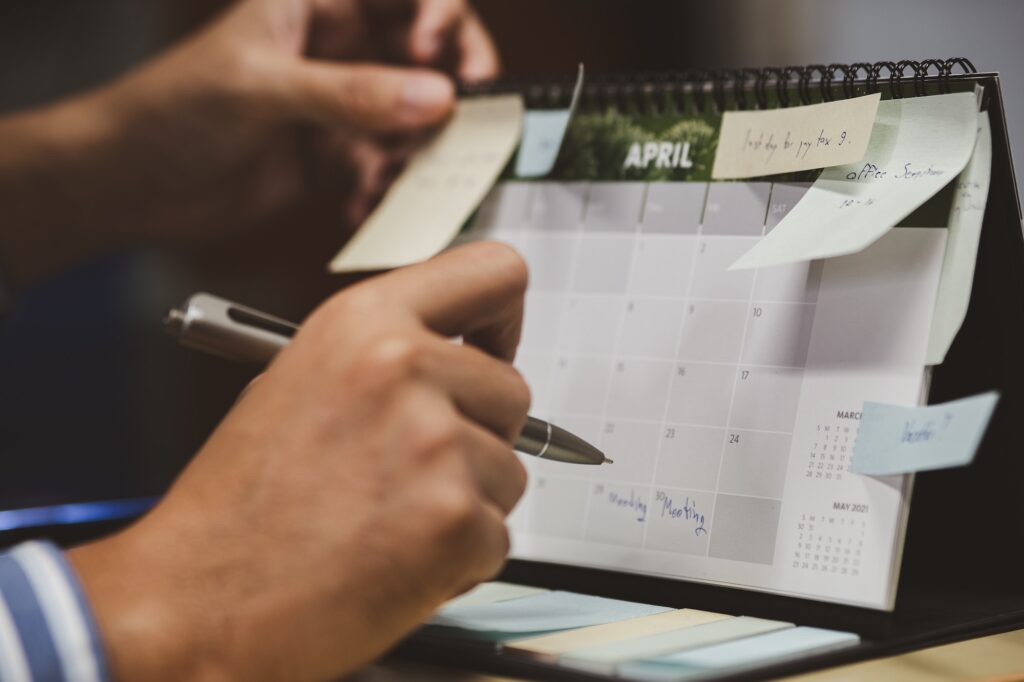 Close up of businessman checking memo and planning schedule on calendar planner