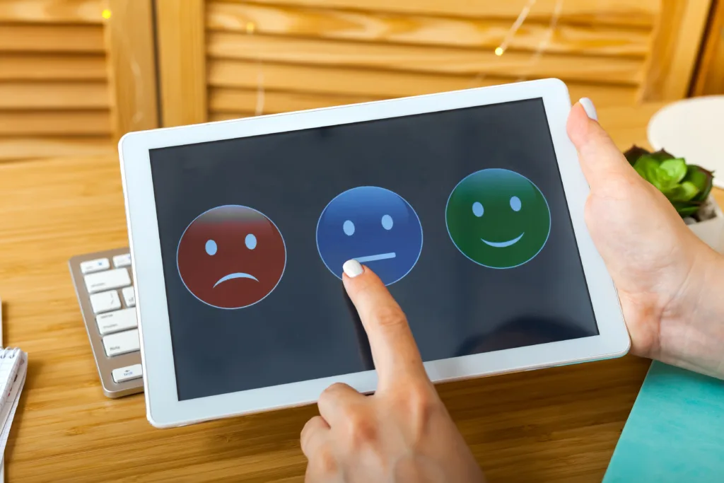 Woman choosing her opinion with smiley faces on touch screen.