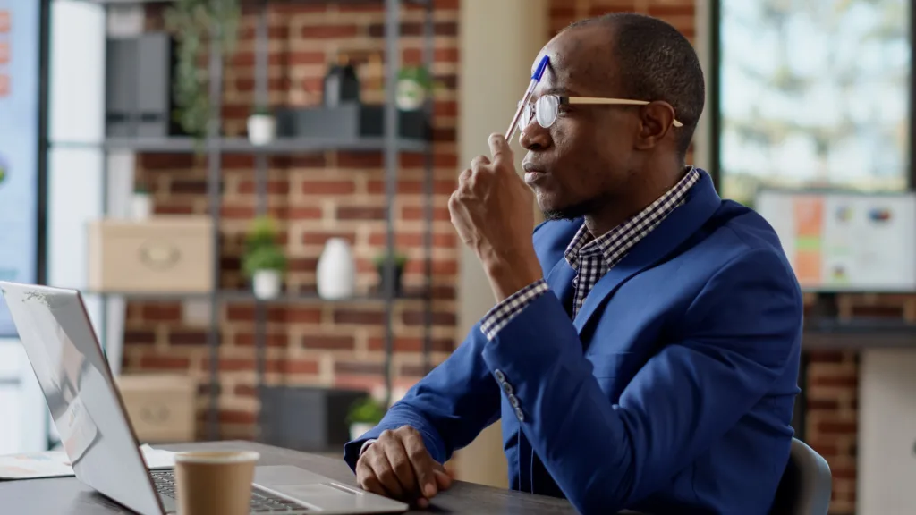 Pensive businessman thinking about report management