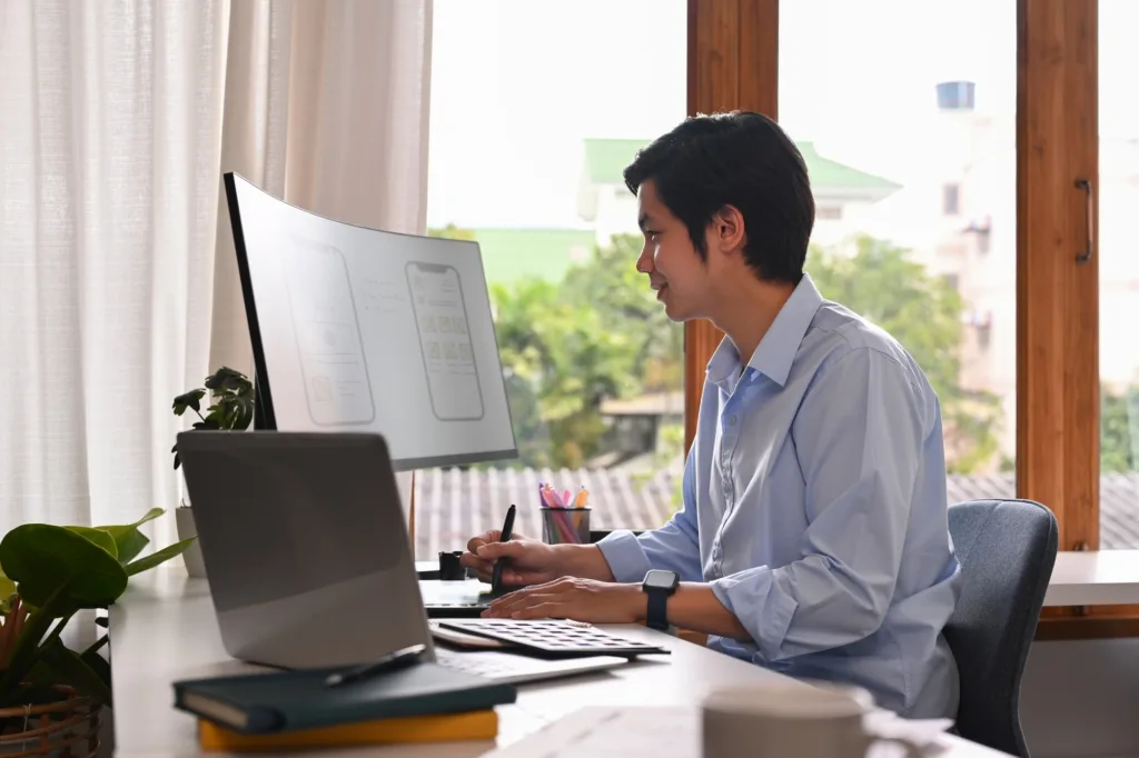 Professional web developer working with prototype wireframe for web management on computer screen.