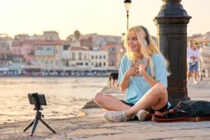 Teenage female blogger recording video content, talking to followers using smartphone