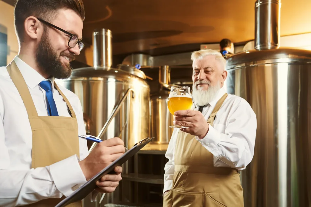 Two brewers standing in brewery and examining quality of ale and making Data-Driven Approach to Microbrewery Marketing